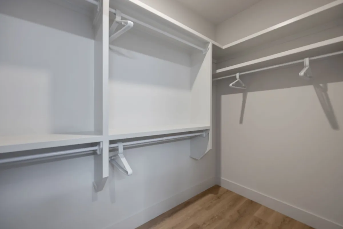 A clean and organized walk-in closet with built-in shelves and hanging rods, ready for guests to unpack and settle in comfortably.