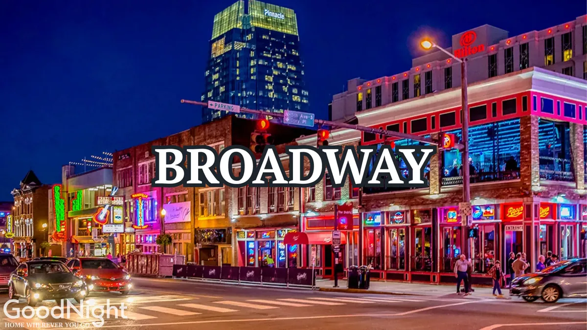 This image captures the energetic nightlife of Midtown Nashville, with neon signs lighting up a bustling street filled with people enjoying dining, live music, and shopping. The scene is lively, with vibrant city lights and a crowd that emphasizes the neighborhood's reputation for entertainment and excitement.